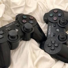 two video game controllers laying on top of a bed