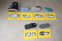 several pairs of shoes sitting on the floor next to yellow cards with black and white images