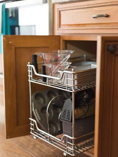 an open cabinet with dishes and utensils in it