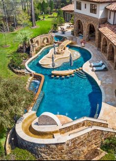 an aerial view of a home with a swimming pool in the foreground and landscaping around it