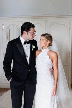 a man and woman in formal wear standing next to each other wearing tuxedos