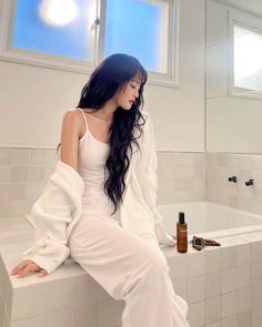 a woman sitting on the edge of a bath tub