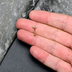 a person's hand holding a tiny diamond ring