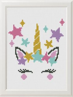 a cross stitch unicorn's head with stars in the background and a white frame