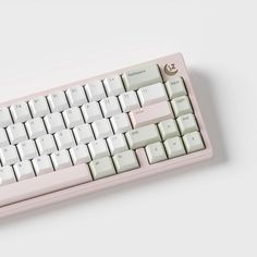 a pink computer keyboard sitting on top of a white table