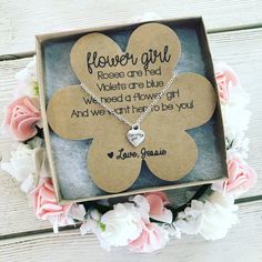 a flower girl necklace in a box with flowers around it and a poem written on the front