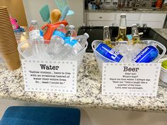 two plastic containers filled with water and bottled beverages on top of a kitchen counter next to a blue stool