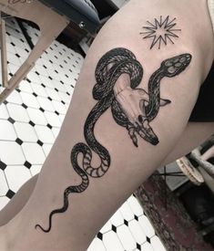 a woman's leg with a snake tattoo on it