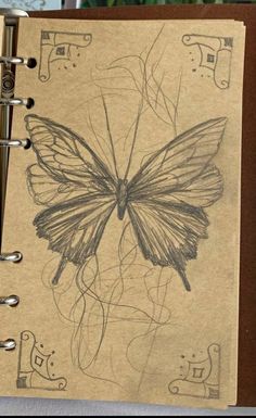 a notebook with a drawing of a butterfly on it