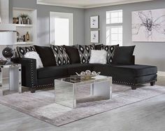 a living room with black couches and white rugs on the floor in front of windows