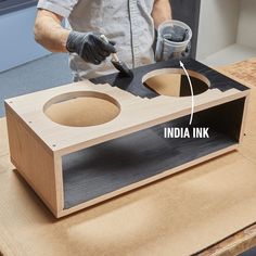 a man is working on an unfinished wooden box with paint and glue in the middle