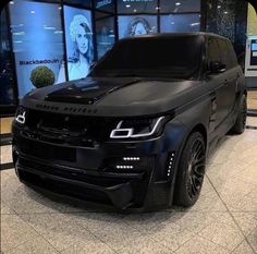 the black range rover is on display in front of some glass windows at an auto showroom