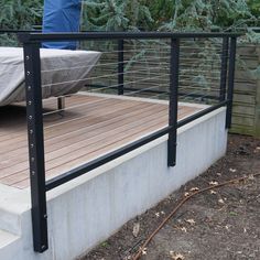 there is a mattress sitting on the back of a deck next to a fenced in area