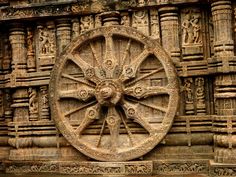 an intricately carved wheel on the side of a building