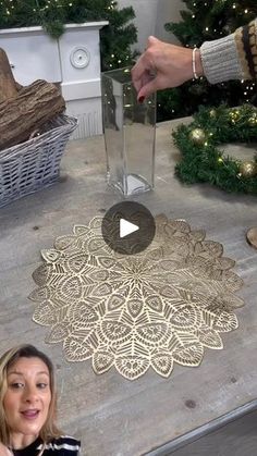 a woman is standing in front of a christmas tree and pointing to the floor with her finger