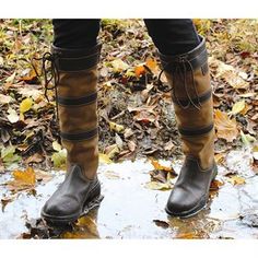 a person standing in the rain wearing brown boots