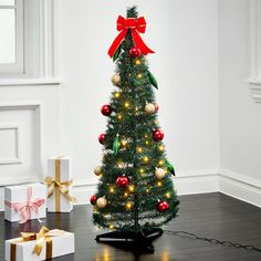 a small christmas tree with red and gold ornaments on it, next to two wrapped presents