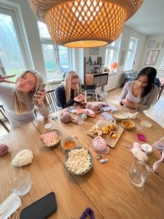 four women sitting at a table with food on it