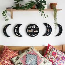 three moon shaped shelves on the wall above a bed