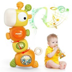 a baby sitting next to a musical toy