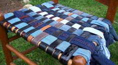 an old wooden rocking chair covered in blue jeans and leather straps, sitting on the grass