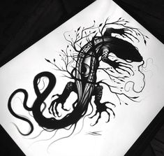 a black and white drawing of a snake on a piece of paper with ink splots