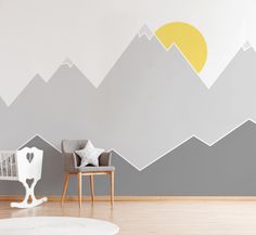 a baby's room with mountains painted on the wall and a crib next to it