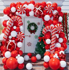 a red and white balloon arch with christmas decorations