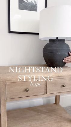 a night stand with two drawers and a white lamp on the end table next to it