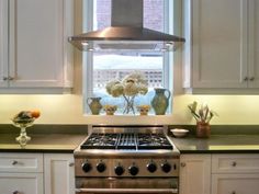 a stove top oven sitting inside of a kitchen next to a window with flowers on it