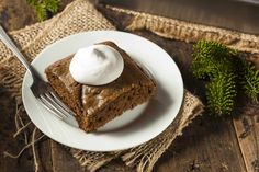 a piece of cake on a white plate with a fork and napkin next to it