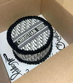 a cake in a box with the word christian dior on it and black ribbon