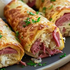 two ham and cheese rolls on a plate with parsley sprinkled around the edges