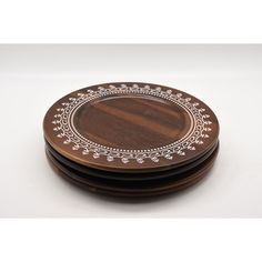 four wooden plates with white designs on them