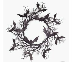 a wreath made out of branches with bats hanging from the top and on it's sides