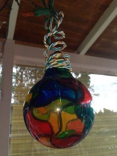 a colorful glass ornament hanging from a ceiling