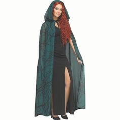 a woman in a black dress and green cape with red hair is posing for the camera