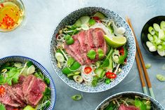 three bowls filled with meat and veggies next to chopsticks on a table