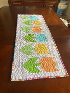 the table runner is made with different colors and designs on it, along with an arrow design