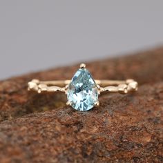 a blue topazte ring sitting on a rock