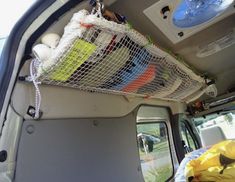 the inside of a van with various items in it's cargo net on the back