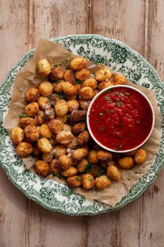 a plate filled with tater tots next to a bowl of ketchup