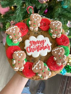 someone holding up a christmas cookie decorated with gingerbreads