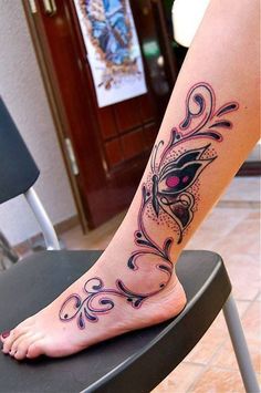 a woman's foot with a butterfly tattoo on the side of her leg,