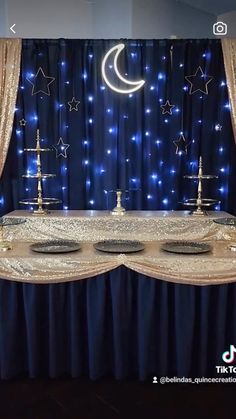 an image of a table setting for a wedding reception with blue lights and stars on the curtain