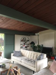 a living room filled with furniture and a fire place under a wooden ceiling over a fireplace