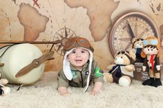 a baby is laying on the floor in front of some stuffed animals and an airplane