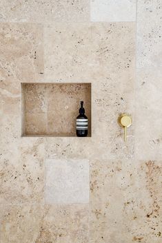 a vase sitting in the middle of a tiled wall next to a door knob and mirror