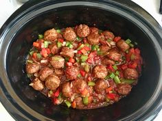 a slow cooker filled with meatballs and veggies on top of it