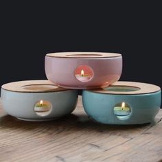 three bowls with candles in them sitting on a table